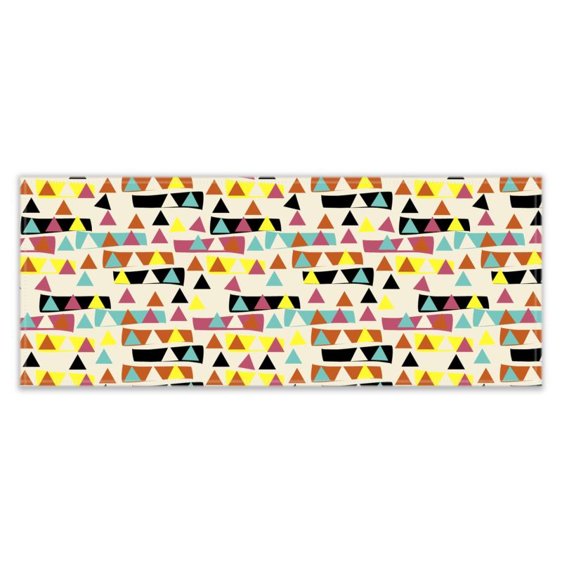 This patterned kitchen table runner has an abstract triangular pattern with triangles inside and outside blocks of orange, yellow, teal and black colours against a cream background