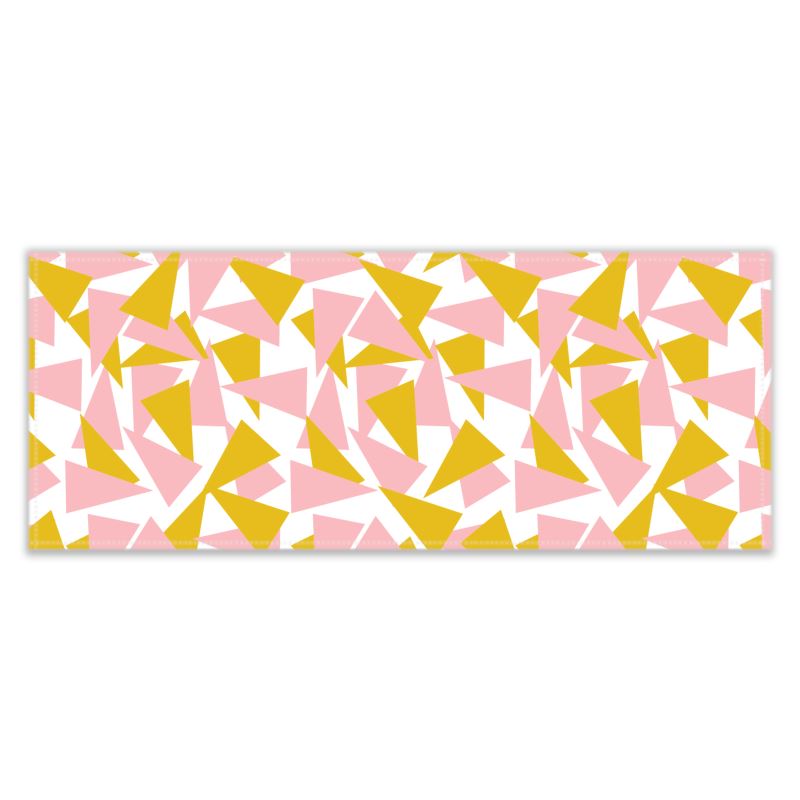The patterned table runner has an abstract geometric triangular pattern in pink and mustard orange against a white background
