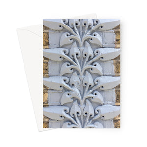Greeting card showing detail of carved stylised leaves painted white on brickwork in Southwark