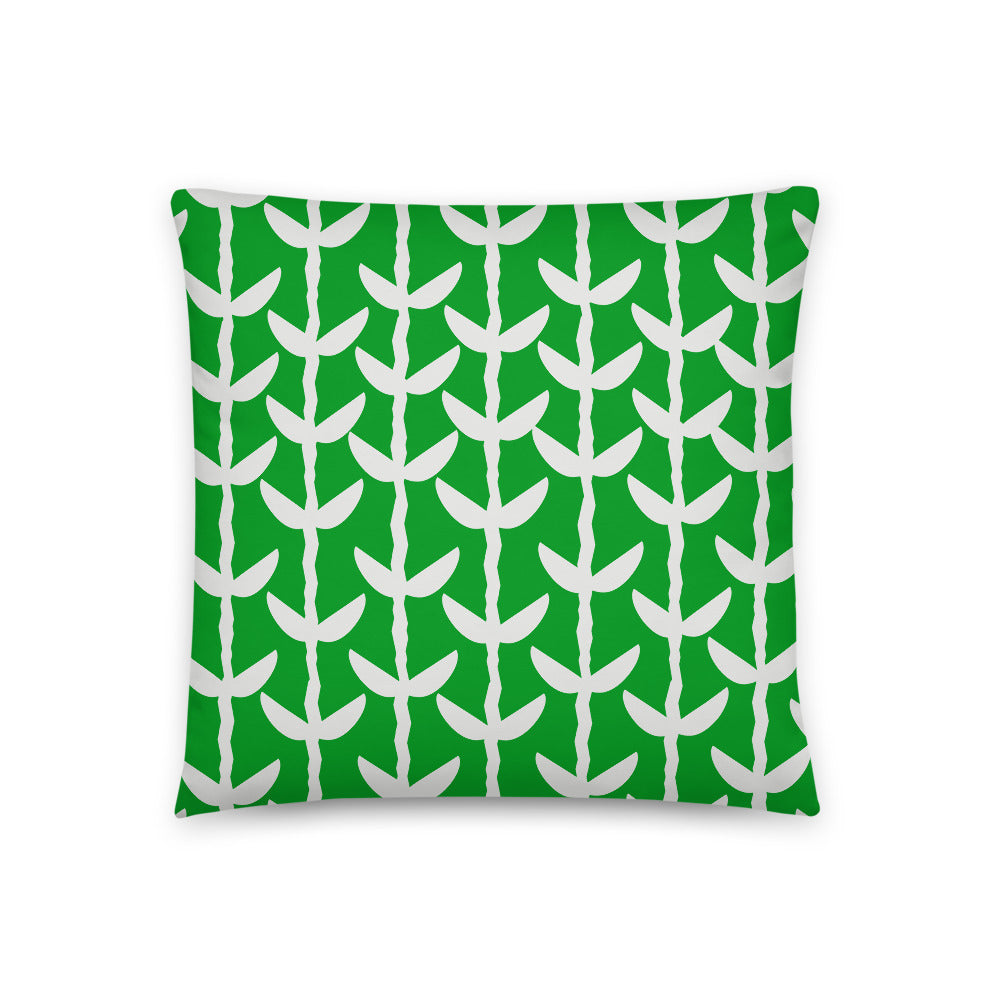 This Mid-Century Modern style couch pillow design consists of a series of cream coloured leaves and stems against an emerald green background