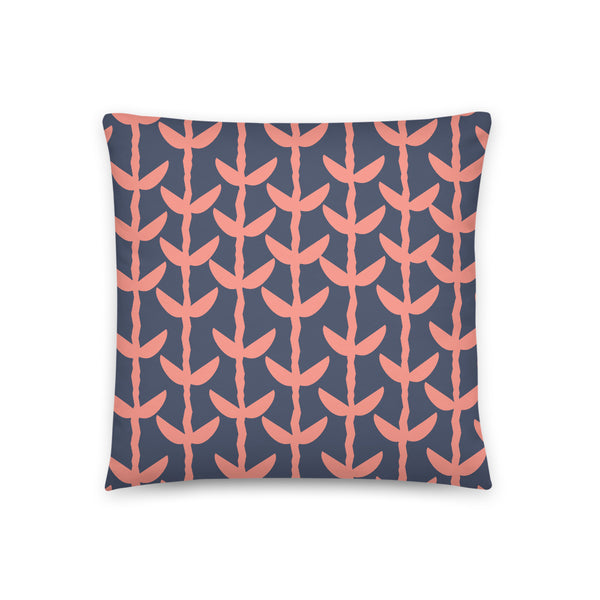 This Mid-Century Modern style couch pillow design consists of a series of salmon pink coloured leaves and stems against a navy blue background