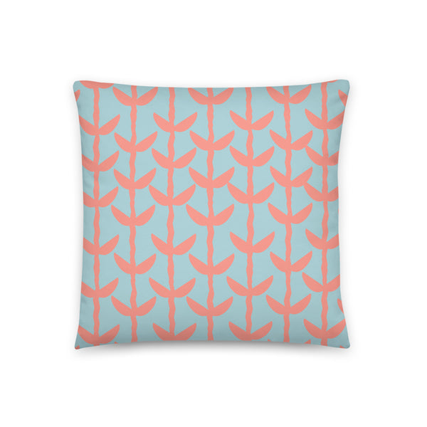 This Mid-Century Modern style couch pillow design consists of a series of salmon pink coloured leaves and stems against a sea foam green background
