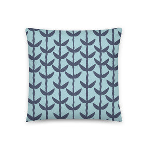 This Mid-Century Modern style couch pillow design consists of a series of navy blue coloured leaves and stems against a sea foam background