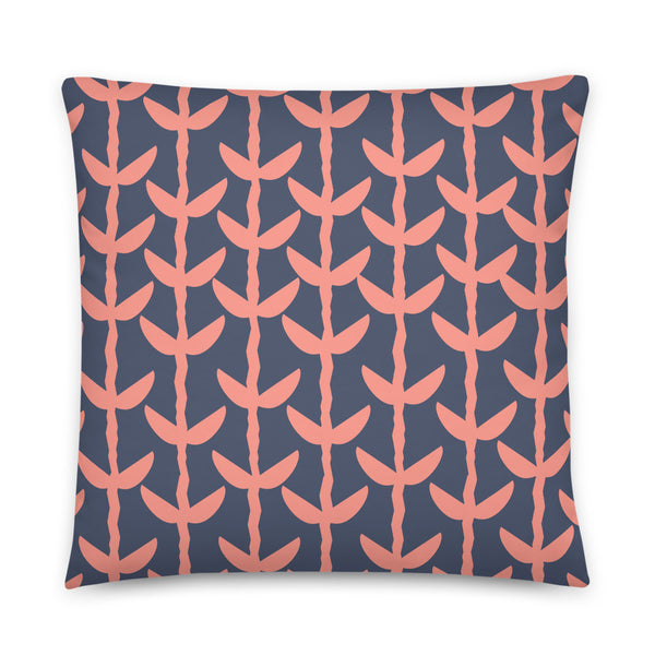 This Mid-Century Modern style couch pillow design consists of a series of salmon pink coloured leaves and stems against a navy blue background