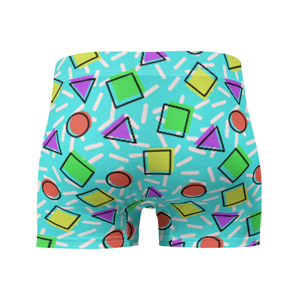 Retro style 80s Memphis design boxer briefs with colourful rainbow primary colors in geometric shapes squares, circles. triangles with a random white pattern below all over a turquoise blue background on this best men's boxer briefs by BillingtonPix