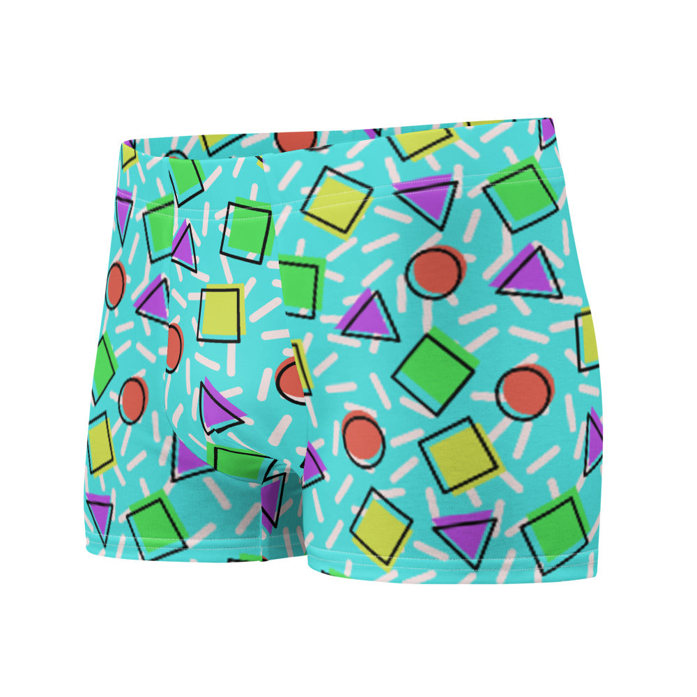 Retro style 80s Memphis design boxer briefs with colourful rainbow primary colors in geometric shapes squares, circles. triangles with a random white pattern below all over a turquoise blue background on this best men's boxer briefs by BillingtonPix