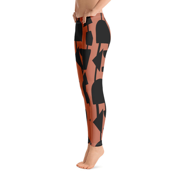 The vintage mid century modern style graphic design printed on the front of these patterned yoga leggings consists of abstract black geometric shapes connected vertically by black threads on an orange background