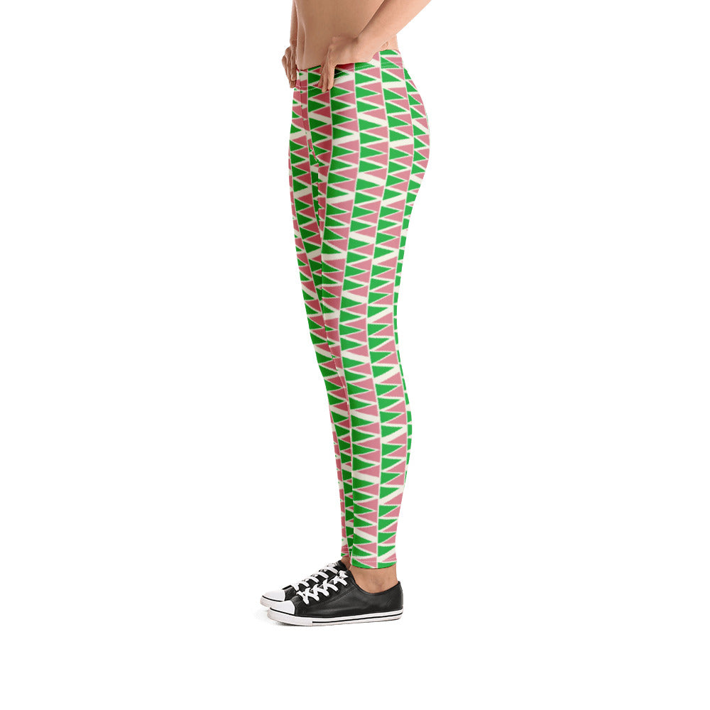 The vintage mid century modern style graphic design printed onto these colorful leggings consists of a geometric triangular pattern in green and pink on a cream background