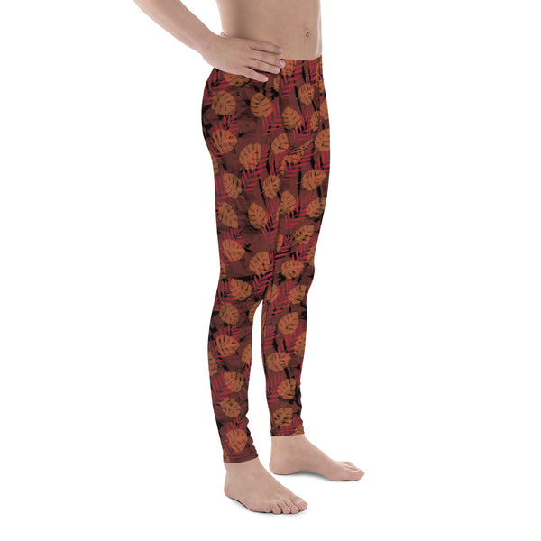 Orange and black autumnal monstera and fern leaves pattern on these spandex and polyester men's leggings by BillingtonPix