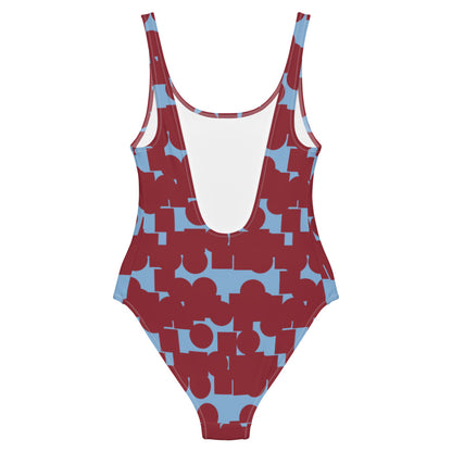 This cheeky, stylish and comfortable, abstract design patterned swimsuit is entitled Crowded Memories and consists of a vermillion red, geometric shapes against a cerulean blue background