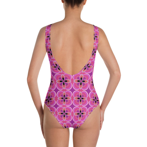 Kitsch vintage retro style one piece swimsuit for women in an abstract floral design in tones of pink, purple, orange and black