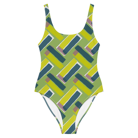 This cheeky, stylish and comfortable, abstract design patterned swimsuit is entitled Forever Connected and consists of diagonal color blocks of olive green, mustard yellow and pink putty in an alternating criss-cross format on a green background
