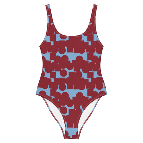 This cheeky, stylish and comfortable, abstract design patterned swimsuit is entitled Crowded Memories and consists of a vermillion red, geometric shapes against a cerulean blue background