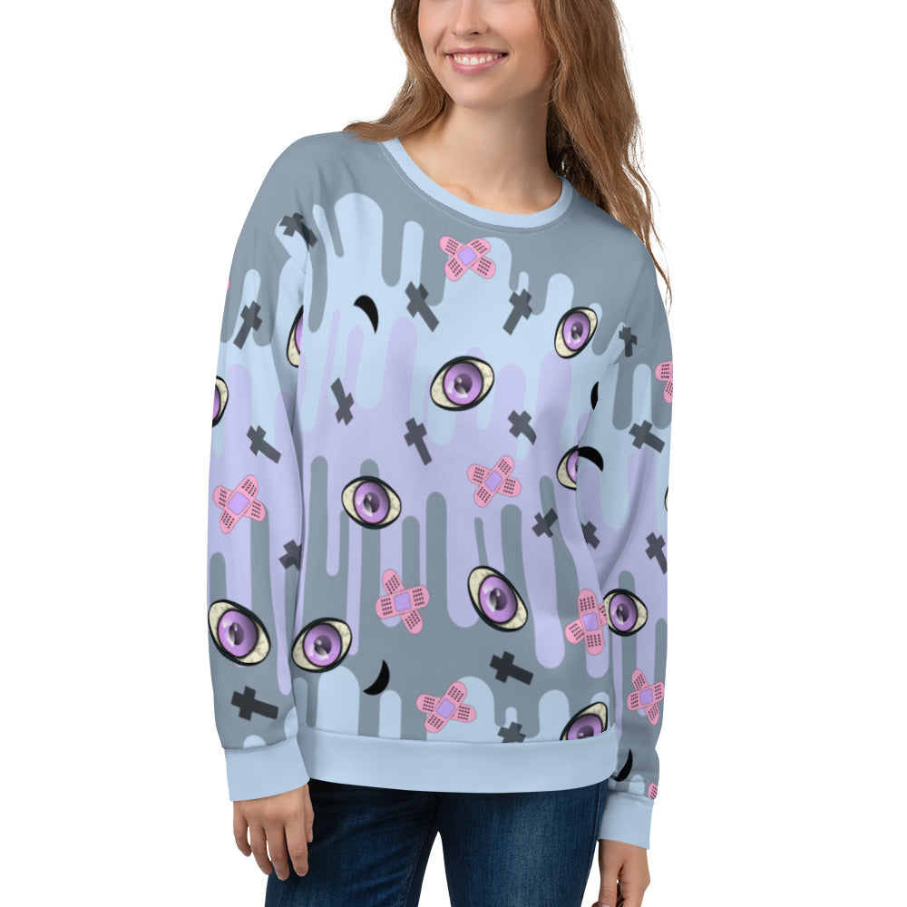 Patterned unisex sweatshirt in a Yami Kawaii Harajuku Pastel Goth aesthetic featuring spooky eyeballs, moons, crosses and sticking plasters for a Menhera Kei fashion look on this pastel colored drip patterned sweater by BillingtonPix