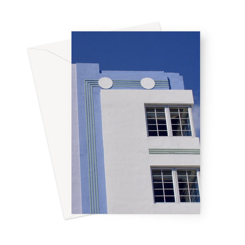 This greeting card shows a gorgeous blue and white Art Deco building with details of geometric lines and circles beneath a deep blue sky