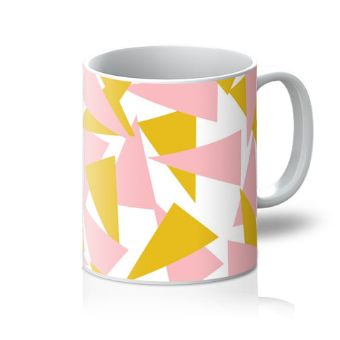 This Mid-Century Modern style ceramic mug consists of colorful triangle shapes in pink and orange on a white background