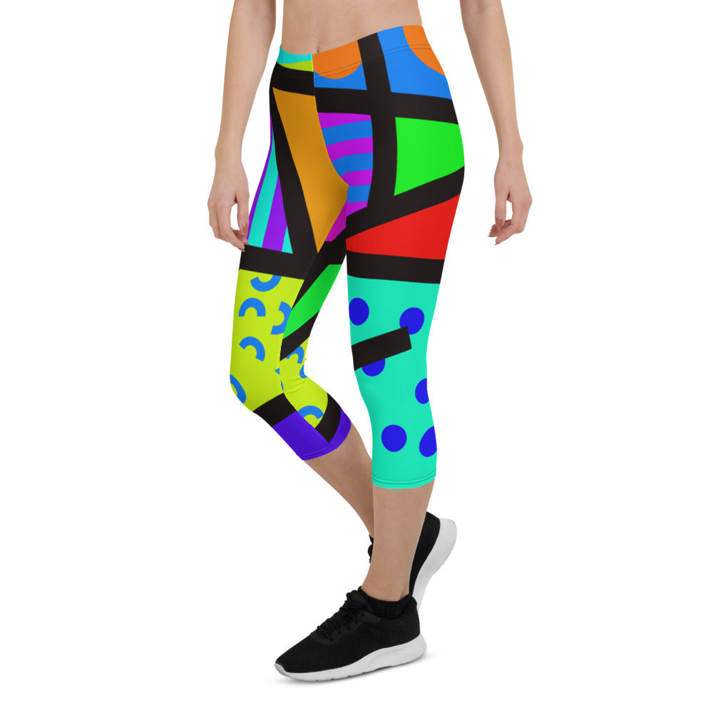 Capri leggings for women in a retro 80s Memphis design. Rainbow colored geometric all-over pattern with black overlay. Calf length legs and mid-rise elastic waistband.