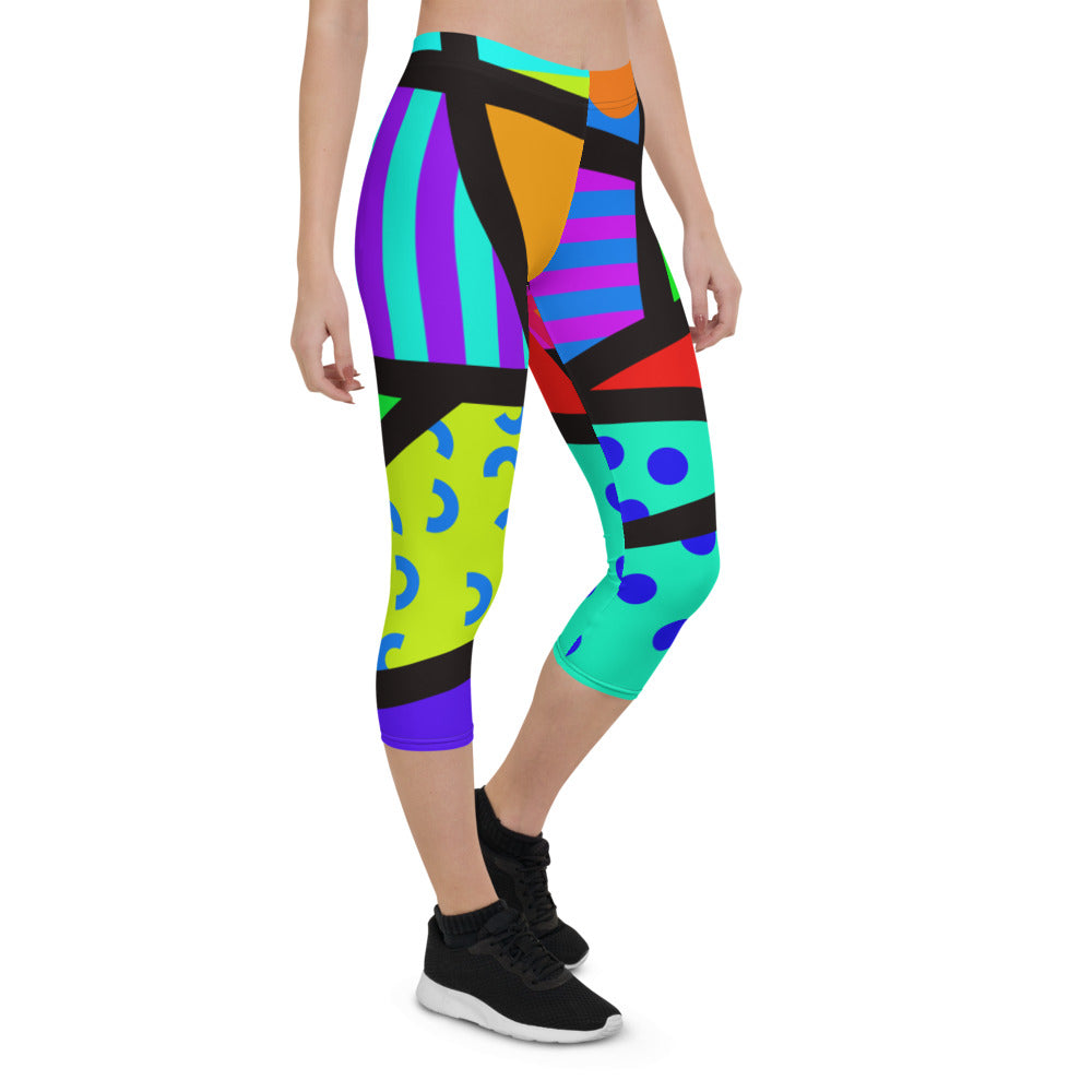 Capri leggings for women in a retro 80s Memphis design. Rainbow colored geometric all-over pattern with black overlay. Calf length legs and mid-rise elastic waistband.