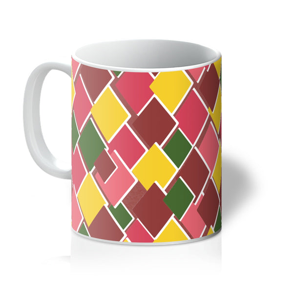 Kitsch 69s style harlequin diamond patterned coffee mug in tones of citrus, leaf green, peach and raspberry in an irregular diamond shaped pattern.