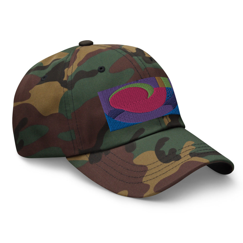 Green camo dad hat with colorful rectangular logo containing blocks of colors of pink, purple, green and blue, curves and geometric shapes in a mid-century modernist abstract composition