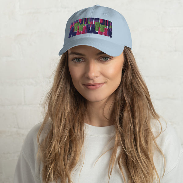 Light blue colored dad hat with retro 60s style geometric pattern logo in threads of lime green, pink, purple and indigo