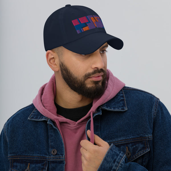 Colorful pink, orange, purple and blue geometric shapes patterned rectangular logo on this navy colored dad hat