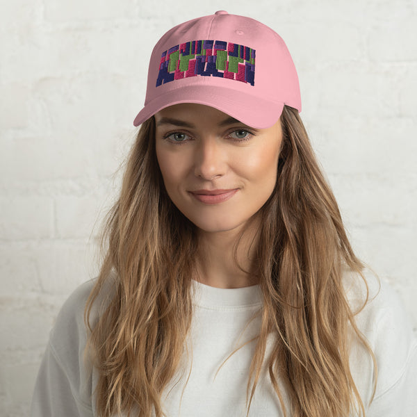 Pink colored dad hat with retro 60s style geometric pattern logo in threads of lime green, pink, purple and indigo