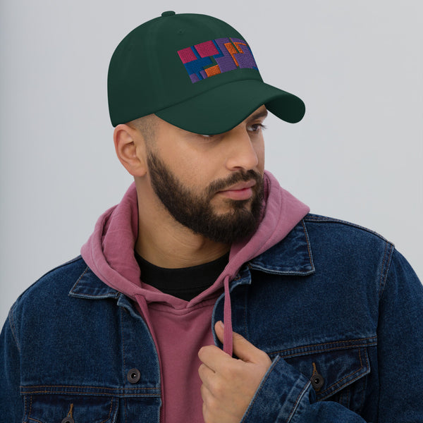 Colorful pink, orange, purple and blue geometric shapes patterned rectangular logo on this spruce colored dad hat