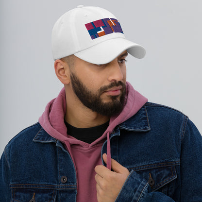 Colorful pink, orange, purple and blue geometric shapes patterned rectangular logo on this white colored dad hat