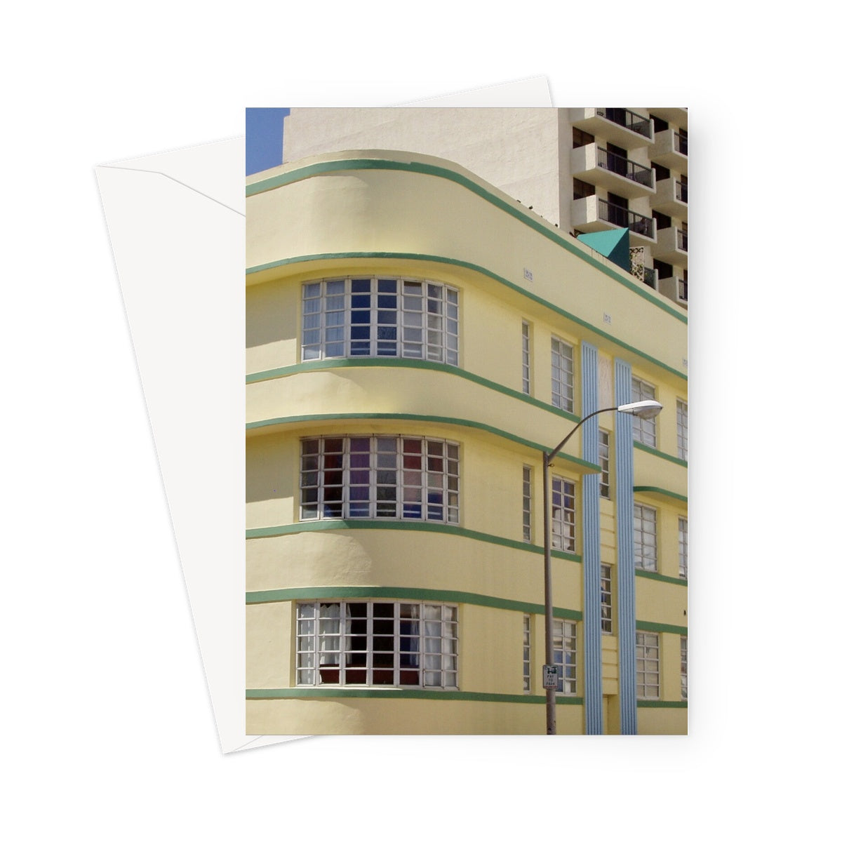 This greeting card shows the corner aspect of a yellow building with green striped edging and canopy, and blue striped column effects.