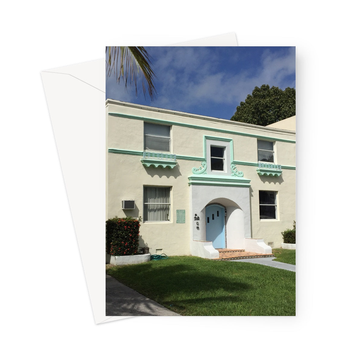 Greeting card shows a pale yellow Art Deco building with pale green scalloped features and pale blue front door