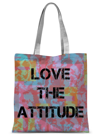 This retro style shopping tote design consists of colorful abstract background with the words Love the Attitude emblazoned across the front