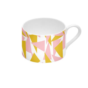 This vintage style bone china cup and saucer set design consists of an abstract triangular pattern in pink and mustard orange against a white background.