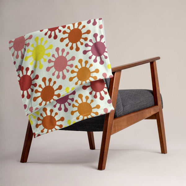 This machine washable Mid-Century Modern style armchair throw consists of colourful virus icons in pink, yellow and orange against a light cream background