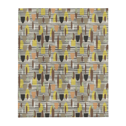 This Mid-Century Modern style couch throw design consists of a series of earthy muted oval shapes in browns, yellow, black and peach against a patterned background of black and grey crisscross and cream colours
