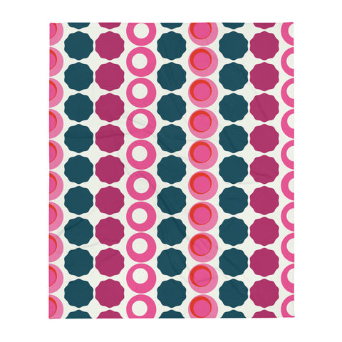 This Mid-Century Modern style couch throw consists of colorful circular and concentric shapes in various tones of pink and top against a light cream background
