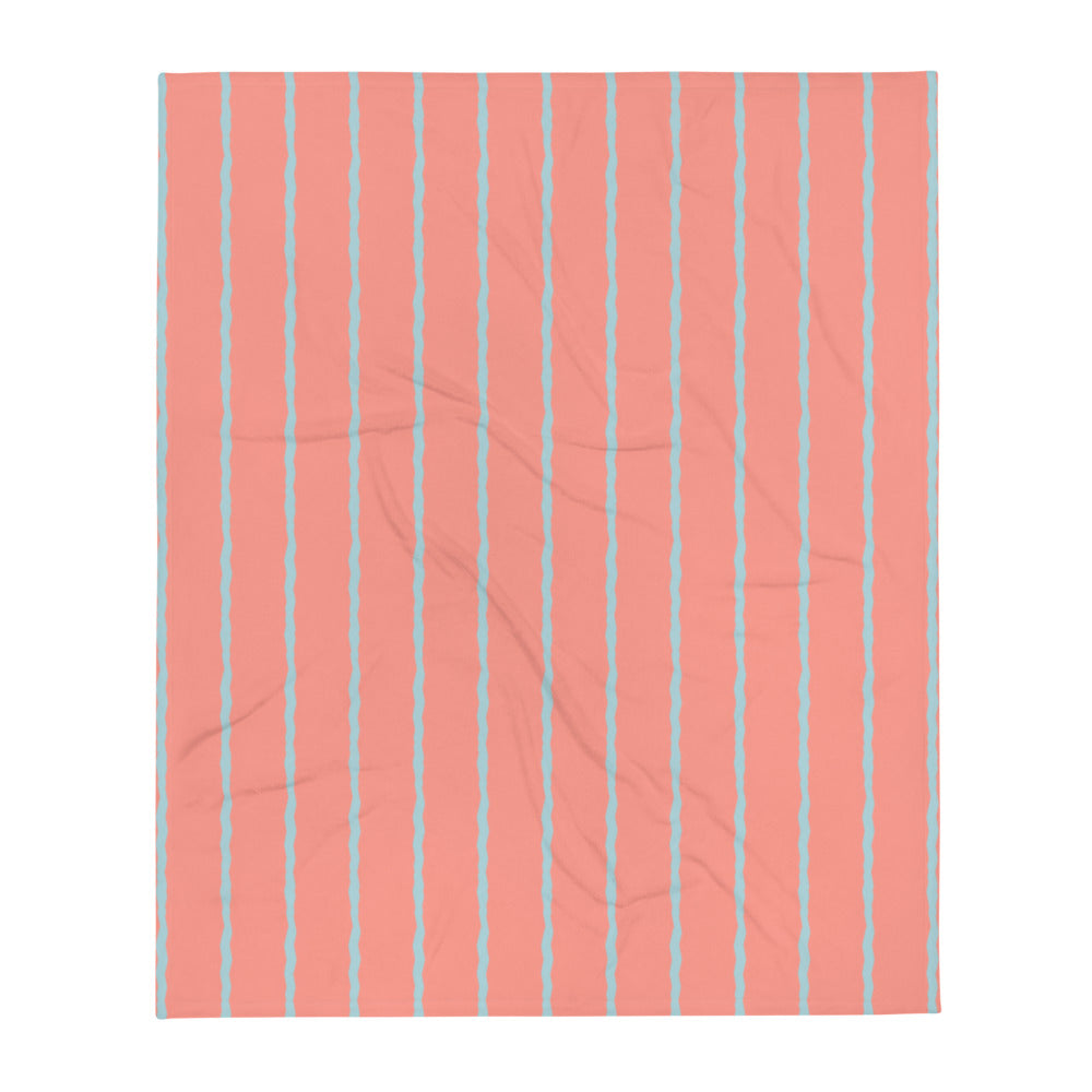  This retro style couch throw consists of jagged vertical seafoam blue stripes against a salmon pink background