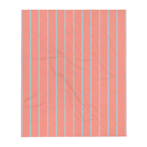  This retro style couch throw consists of jagged vertical seafoam blue stripes against a salmon pink background