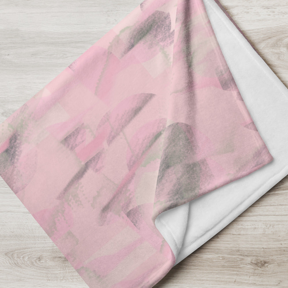 Throw blanket with a subtle pink colored abstract repeat pattern with hints of green and an abstract patterned background