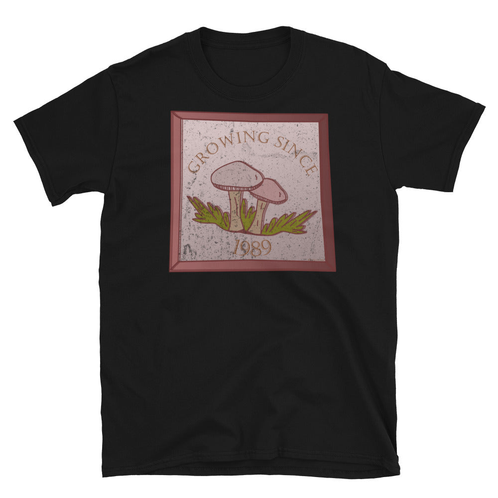 Growing since 1989 cute Goblincore style design with two mushrooms in muted tones and a glass framed effect with distressed look on this black cotton t-shirt by BillingtonPix