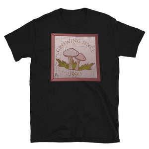 Growing since 1990 cute Goblincore style design with two mushrooms in muted tones and a glass framed effect with distressed look on this black cotton t-shirt by BillingtonPix