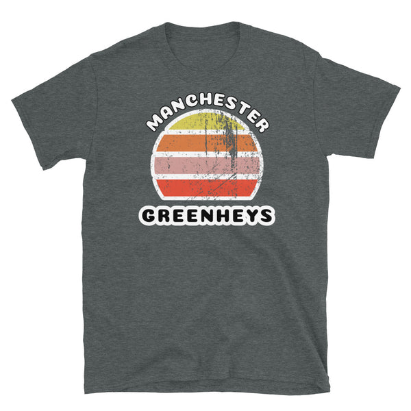 Distressed style abstract retro sunset graphic in yellow, orange, pink and scarlet stripes. The name of Manchester is displayed at the top wrapped around the sunset. Below the retro sunset design is the famous Manchester place name of Greenheys on this dark heather cotton t-shirt.