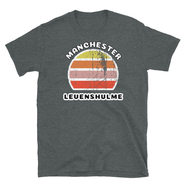 Distressed style abstract retro sunset graphic in yellow, orange, pink and scarlet stripes. The name of Manchester is displayed at the top wrapped around the sunset. Below the retro sunset design is the famous Manchester place name of Levenshulme on this dark grey cotton t-shirt.