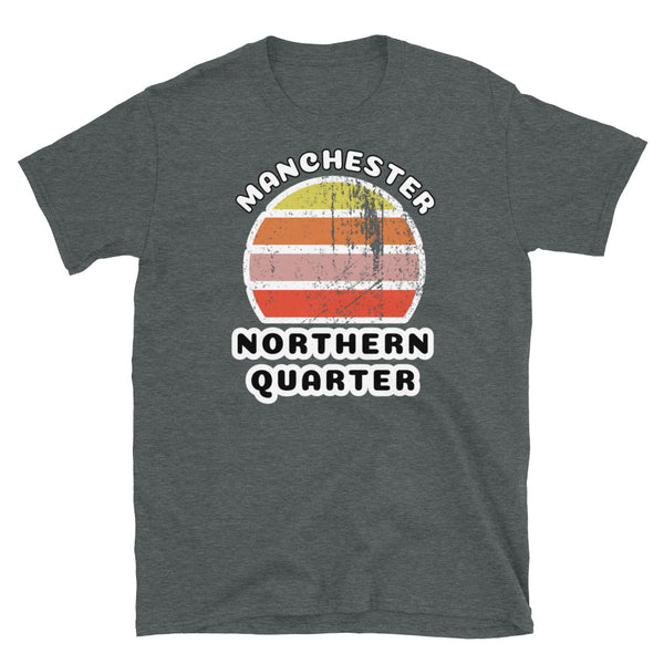 Distressed style abstract retro sunset graphic in yellow, orange, pink and scarlet stripes. The name of Manchester is displayed at the top wrapped around the sunset. Below the retro sunset design is the famous Manchester place name of Northern Quarter on this dark grey cotton t-shirt.