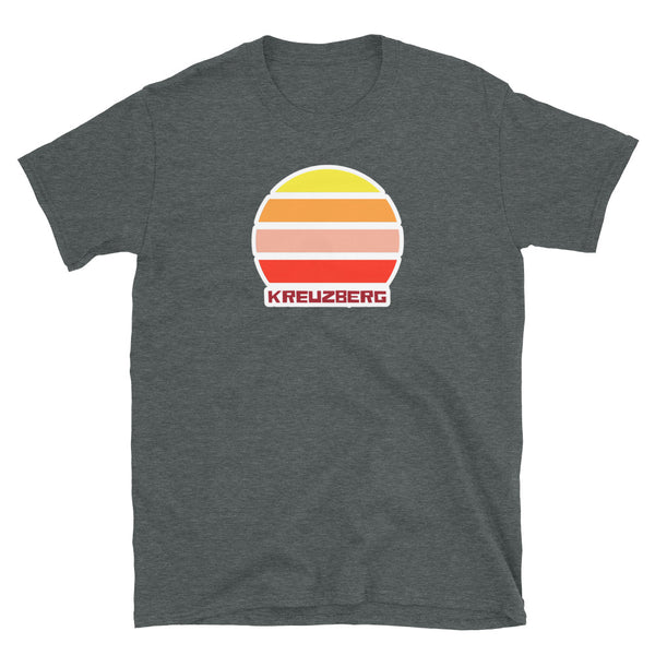 Kreuzberg Berlin LGBT themed t-shirt with a vintage sunset graphic in yellow, orange, pink and scarlet and the place name Kreuzberg  beneath on this dark grey cotton t-shirt by BillingtonPix