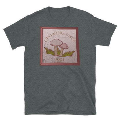 Growing since 1997 cute Goblincore style design with two mushrooms in muted tones and a glass framed effect with distressed look on this dark heather cotton t-shirt by BillingtonPix