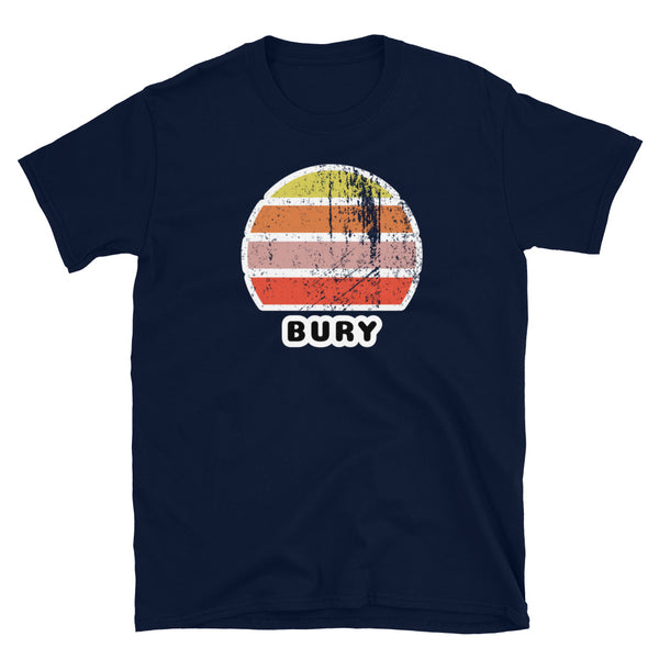 Features a distressed abstract retro sunset graphic in yellow, orange, pink and scarlet stripes rising up from the famous Manchester place name of Bury on this navy t-shirt