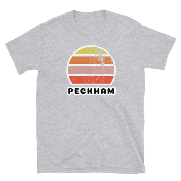 Vintage retro sunset in yellow, orange, pink and scarlet with the name Peckham beneath on this sport grey t-shirt