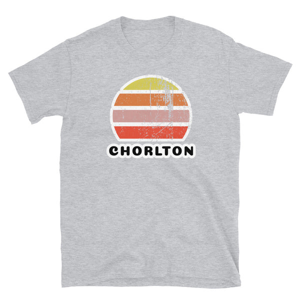 Features a distressed abstract retro sunset graphic in yellow, orange, pink and scarlet stripes rising up from the famous Manchester place name of Chorlton on this sport grey t-shirt