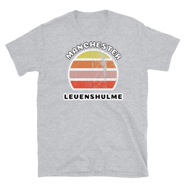 Distressed style abstract retro sunset graphic in yellow, orange, pink and scarlet stripes. The name of Manchester is displayed at the top wrapped around the sunset. Below the retro sunset design is the famous Manchester place name of Levenshulme on this light grey cotton t-shirt.